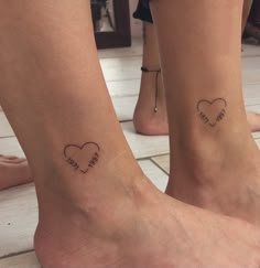 two people with matching tattoos on their feet, one has a cross and the other has a heart