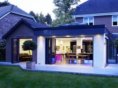 a house with an open patio and dining area in the back yard at night time