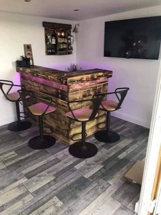 a bar made out of pallet wood with three stools