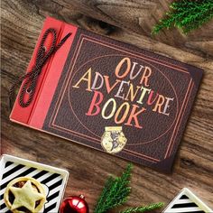 an adventure book surrounded by christmas decorations on a wooden table with pine cones and ornaments