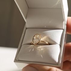 a person is holding an engagement ring in a box