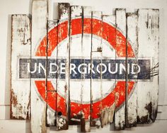 an old wooden sign with the word underground painted on it's side in red and white