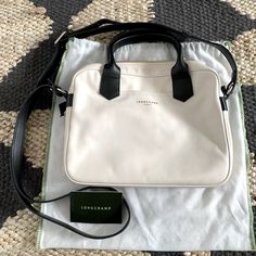 Beautiful Longchamp Satchel. Nwot. Comes With Dustbag. In Very Rare Cream Leather With Black Trim. Top Handles And Shoulder Strap. Inside Is Textile Lined And Has Zippered Pocket And Two Open Pockets, Along With Key Clip Tether. Dimensions Of Bag (Not Including Top Handles) Are Approximately L 20” X W 2” X H 8”. White Leather Handles Shoulder Bag For Business, White Bags With Leather Trim For Formal Occasions, White Formal Bag With Leather Trim, White Leather Trim Formal Bag, Formal White Bags With Leather Trim, Classic White Shoulder Bag With Leather Trim, Longchamp Leather, Longchamp Bags, Key Clip