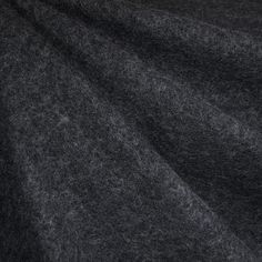 a close up view of the dark grey wool fabric that has been made into a blanket