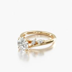 a yellow gold engagement ring with two diamonds on the side and an oval diamond in the center