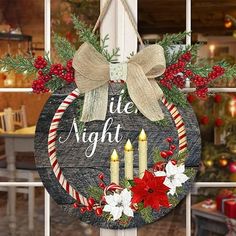 a wooden sign that says little night with candles and poinsettis on it