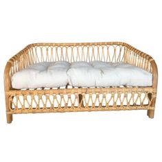 a wicker couch with two pillows on it's back and one pillow in the middle