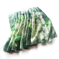 Silk scarf Liliy of the Valley is a hand painted scarves decorated with white flowers on green shawl. This silk wrap is designed for perfect woodland wedding! Silk: pure Habotai Light, semi transparent and delicate. Requires hand washing. Hand painted, so the pattern is equally visible on both sides. This scarf can be ordered in two sizes: - 61 in by 17 in (155 by 43 centimeters) AS IN THE PICTURE - 80 in by 34 in (198 by 88 centimeters) The Lilies of the Valley scarf is hand painted with large Green Silk Shawl For Wedding, Green Floral Print Scarf For Gift, Green Floral Print Scarves As Gift, Green Shawl Scarf As Gift, Green Shawl Scarf As A Gift, Bride Shawl, Pastel Scarf, Rustic Woodland Wedding, Green Shawl