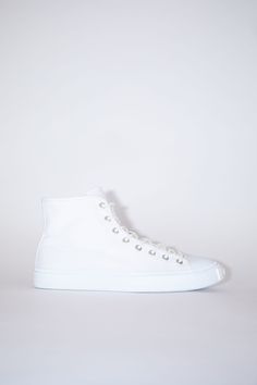 Acne Studios optic white high top sneakers are made from cotton with rubber soles. Completed with a branded logo tag on the front. Ballow High Tag M High-top Canvas Sneakers With Textured Sole, Modern White High-top Sneakers With Vulcanized Sole, Casual White High-top Sneakers With Textured Sole, High-top Cotton Canvas Shoes With Textured Sole, Canvas High-top Sneakers With Textured Sole For Streetwear, Modern High-top Canvas Sneakers With Contrast Sole, White High-top Sneakers With Textured Sole For Streetwear, Casual High-top Sneakers With Rubber Heel Cap, Classic Canvas High-top Sneakers