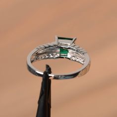 It is a lab emerald ring. The main stone is 6 mm*6 mm princess cut.weight about 0.93 carats. The basic metal is sterling silver and plated with rhodium. To change the metal to a solid gold (white/rose) or platinum is also available, please ask for a quotation if you want. You can also go to my shop Home for more elegant rings: https://www.etsy.com/shop/godjewelry?ref=hdr_shop_menu Emerald is the May birthstone More emerald rings: https://www.etsy.com/shop/godjewelry?section_id=20709240 Customiza Princess Cut Emerald Promise Ring, Cubic Zirconia Emerald Ring With Princess Cut, Princess Cut Cubic Zirconia Emerald Ring With Prong Setting, Emerald Princess Cut Ring With Prong Setting, Princess Cut Emerald Jewelry, Silver Emerald Ring With Princess Cut, Anniversary Princess Cut Cubic Zirconia Emerald Ring, Princess Cut Cubic Zirconia Emerald Ring For Anniversary, Silver Emerald Ring Princess Cut