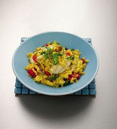 a blue bowl filled with food on top of a table