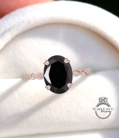 an oval black diamond ring with diamonds around it