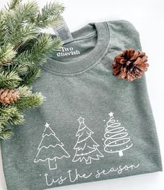 This T-shirt is made of 100% Cotton. Gildan Brand T-shirt  The design is made out of HTV ( Heat Transfer Vinyl) and applied with a heat press to secure design.  This listing is for one (1) 'tis the season with Christmas trees on T-shirt.  This T-shirt is perfect for the holiday/ Christmas season. Care Instructions: -Turn inside out and machine wash cold -Hang dry or tumble dry on low heat -Do not iron on design -Do not bleach **Keep in mind that monitors have different color settings, so the col Happy Holidays Shirt, Holiday T Shirt Ideas, Holiday Tshirts Ideas, Christmas Tree Shirt Ideas, Cricut Heat Press Projects, Christmas Shirts Cricut, Christmas Cricut Shirts, Cricut Christmas Shirts, Htv Shirt Ideas