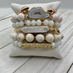 "Elevate your style to new heights with our 'Cloud Nine Chic' bracelet stack – where sass meets sophistication in a sky-high celebration of fabulousness! These bracelets aren't just accessories; they're your personal cloud of chic, ready to whisk you away to a realm where every day is a fabulous adventure. A Real Stunner - Reach for this beautiful stack when you want to stand out from the crowd. Wear them all on one wrist and stack 'em up or wear 3 on one wrist and 3 on the other your favorite watch! Lead & Nickel Free Bracelets are 'one size fits most' and are designed to fit wrists up to 7.5" comfortably Set of 6 Bracelets (4 Stretch, 1 Gold Arrow Cuff & a Gold Bar with a white Druzy Stone Inlay) Pave Crystals Quartz Natural Stone Off White and White Hues Please be aware that due to the White Stackable Bracelets For Party, Elegant Adjustable Stacked Beaded Bracelets, Elegant Adjustable Stacked Bracelets, Trendy White Stackable Jewelry, White Trendy Stackable Jewelry, Chic White Beaded Bracelets, Chic White Beaded Bracelet, Trendy White Stacked Bracelets, Trendy White Crystal Bracelet For Party