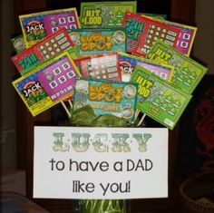 a vase filled with lots of candy sitting on top of a table next to a sign that says lucky to have a dad like you