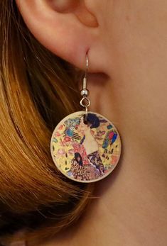 "Lady With A Fan - Gustav Klimt Show your love for the fine arts with our unique handmade earrings. You can wear these enchanting accessories at any given time and occasion to show others you're just as beautiful the painting. ✷ HANDMADE ✷  Handmade with love and care with high-quality wood and metal. Handcrafted in Finland with locally bought materials. ✷ Weatherproof ✷  The earrings have been coated with a weatherproof coating spray. No need to worry about rain!  ✷ Allergy-friendly ✷  All of our earrings are made with nickel tested / nickel free materials to insure that everyone's ears are safe wearing our earrings.  ✷ A Great Gift for Art Lovers ✷  You can also give our earrings to friends, family members, or art lovers on occasions such as birthday, mother's day, Christmas, anniversary Artisan Earrings With Artistic Design As A Gift, Artisan Earrings With Artistic Design For Gift, Vintage Artistic Design Earrings As A Gift, Vintage Earrings With Artistic Design As Gift, Vintage Earrings With Artistic Design For Gift, Artistic Hand Painted Earrings For Gifts, Artsy Dangle Earrings With Artistic Design, Artsy Silver Jewelry For Crafting, Artisan Earrings With Artistic Design