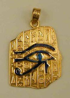 an egyptian gold pendant with the eye of horush on it's side