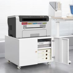 a printer sitting on top of a white cabinet