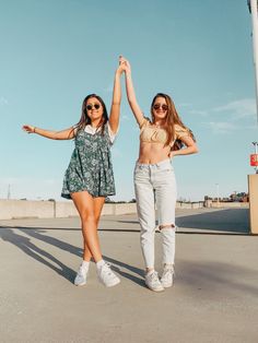 two young women standing next to each other in front of a light pole and street sign