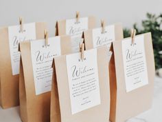 small brown paper bags with white and black wedding menus hanging from clothes pegs