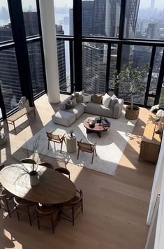 a living room filled with lots of furniture and large windows overlooking the cityscape