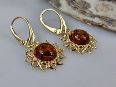 Welcome to handmade Baltic Amber jewelry shop. This Item is made of genuine, natural Amber. This item will make You look simple but gorgeous. Sun shape earrings. Brown Baltic amber jewelry. Amber earrings, lever back closure. Real gemstone dangle earring. Crystal hanging earrings. Flaming sun shape.  Each pair color is slightly different. Gold plated sterling silver 925.   Length: about 3,3 cm Our handmade jewelry is made with passion and love. If you have any problems with your order please contact us. Please note that colors can vary from originals depending on computer monitor's settings. Due to amber is being unique and natural gemstone, each item may be slightly different in shades or shapes. Items may have natural imperfections like lines and spots, specks, coloration and inclusions, Faberge Jewelry, Crystal Hanging, Baltic Amber Jewelry, Headpiece Jewelry, Amber Earrings, Earring Gold, Gift For Sister, Natural Amber, Jewelry Lookbook