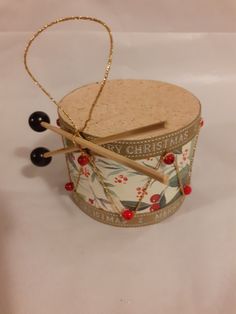 a small box with two wooden sticks sticking out of it's top and some beads on the bottom