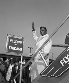 a black and white photo of a man waving to the crowd at an air port