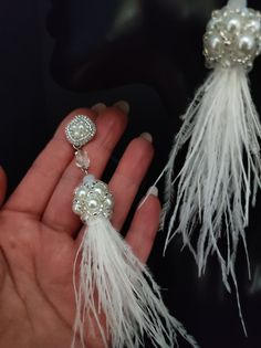 These beautiful earrings are made entirely by hand with beads and real ostrich feathers. The feathers are collected in a beautiful component created of pearls and beads. The pins are handmade with beadembroidery technique with beads and silver synthetic leather is applied from the back. The pin is connected to the tassel with a crystal bead. These earrings are quite long but are very light for the natural materials used. The white feathers and pearls give a very elegant and romantic look. These earrings are also perfect for your special day... a wedding or other important party. All jewels are delivered in a decorated box, ready to be given as a gift to your loved one. How to take care of your jewellery: put on your beauty products (cosmetics, perfumes, ...) before wearing your precious je White Feather Dangle Earrings, Elegant Feather Dangle Jewelry, Elegant Adjustable Feather Earrings, Elegant Feather Dangle Earrings, Elegant Dangle Feather Earrings, Elegant Dangle Earrings With Feathers, Elegant Feather Drop Earrings, Elegant Feather Earrings, Bohemian Handmade Tassel Earrings For Wedding