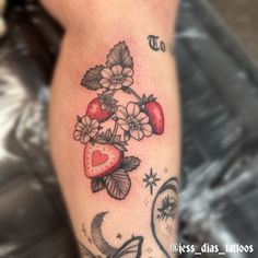 a woman's leg with flowers and hearts tattooed on her arm, next to an apple