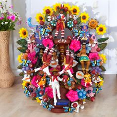 a colorfully decorated tree with flowers and figurines