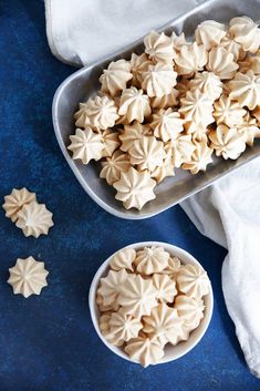 some cookies are in bowls on a blue table