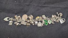 Incredible vintage / antique charm bracelet. 26 unique charms: 1.Frying pan with an egg. Stamped "Sterling". 2.February Pisces charm with two fish and "February". Stamped "Sterling". 3.A skateboard with moving wheels. Stamped "Sterling". 4.Double, baby shoes, charm. Jeweler verified as Sterling Silver.  5.A mailbox charm, with a heart on the front and moveable flag. Stamped "Sterling". 6.Double hart charms. Stamped "Mexico". Jeweler verified as Sterling Silver.  7.A comedic pig cartoon figure, holding u one finger and holding a shovel or cement spatula. It is stamped with a copyright symbol. Jeweler verified as Sterling Silver.  8.LaMode Guilloche Enamel Rose Heart Charm with a mint green background. Stamped "Sterling" and "LAMODE".  9.A four-leave clover with dark green enamel work. Stamp Luxury Metal Charm Bracelet With Vintage Charm, Antique Jewelry With Dangling Charms For Collectors, Heirloom Charms Jewelry For Collectors, Victorian Sterling Silver Charm Jewelry, Antique Dangling Charms For Jewelry Making, Collectible Sterling Silver Jewelry With Vintage Charm, Collectible Vintage Charm Costume Bracelet, Antique Silver Heirloom Jewelry With Vintage Charm, Vintage Handmade Collectible Charm Bracelet