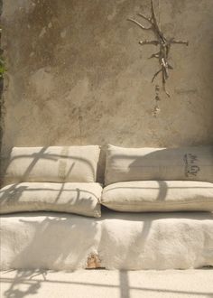 a white couch sitting in front of a cement wall