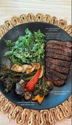 a plate with steak, vegetables and meat on it sitting on a woven place mat