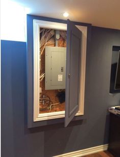 an electrical box is in the middle of a room with blue walls and wood floors