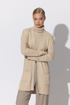 The LUSANA Thea Long Knitted Cardigan is the perfect embodiment of modern luxury. Crafted from organic cotton, this mid-thigh length cardigan has a beautiful open front neckline and elegant gold button cuff detail, as well as two front patch pockets for added convenience. Wear it with a simple dress or layered over the coordinating THEA SLEEVELESS TURTLENECK for an effortless, yet sophisticated look. **Sizing notes: This style runs TTS. Model is wearing a size S. MATERIALS: 100% Cotton CARE: Mac Long Knitted Cardigan, Long Knit Cardigan, Sleeveless Turtleneck, Simple Dress, Cuff Detail, Knitted Cardigan, Gold Buttons, Simple Dresses, Modern Luxury