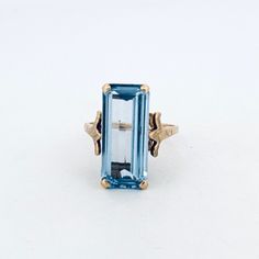 an aquamarine colored stone ring with two gold accents