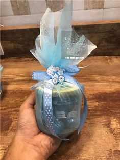 a hand is holding a blue and white gift bag