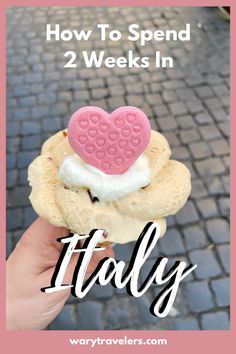 someone is holding up a heart shaped pastry with the words how to spend 2 weeks in italy