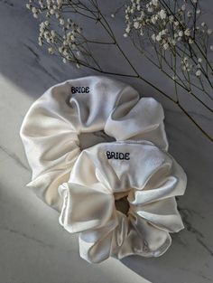 two white scrunffles with the words bride and groom written on them next to flowers