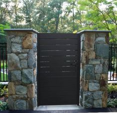 an entrance to a park with stone walls and gates