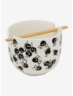 a bowl with chopsticks in it that has black and white pictures on it