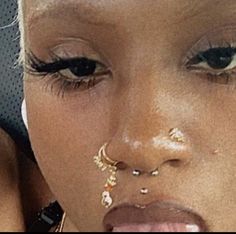 a close up of a person with piercings on her nose and nose ring in front of their face