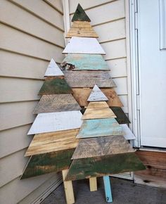 a wooden christmas tree sitting on top of a porch