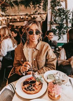 a woman sitting at a table with food in front of her