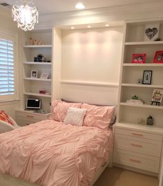 a bedroom with white shelving and pink bedding