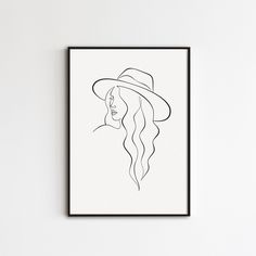 a black and white drawing of a woman with long hair in a hat on a wall