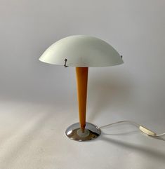 an orange and white lamp sitting on top of a table