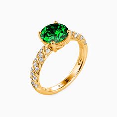 a gold ring with a green stone surrounded by white diamonds on the sides and an oval cut